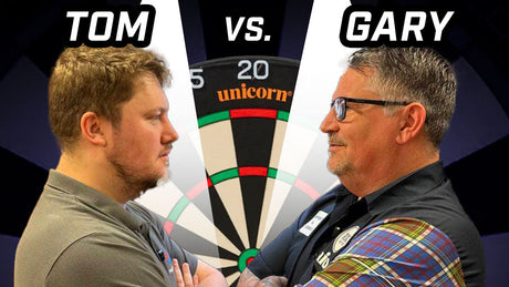 Tom and Gary Anderson face off with a Unicorn dartboard between them.