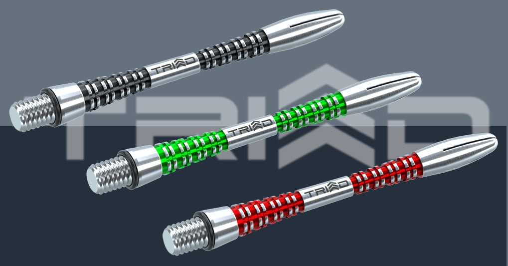 Three Triad dart stems in silver with black, green, and red textured grips.